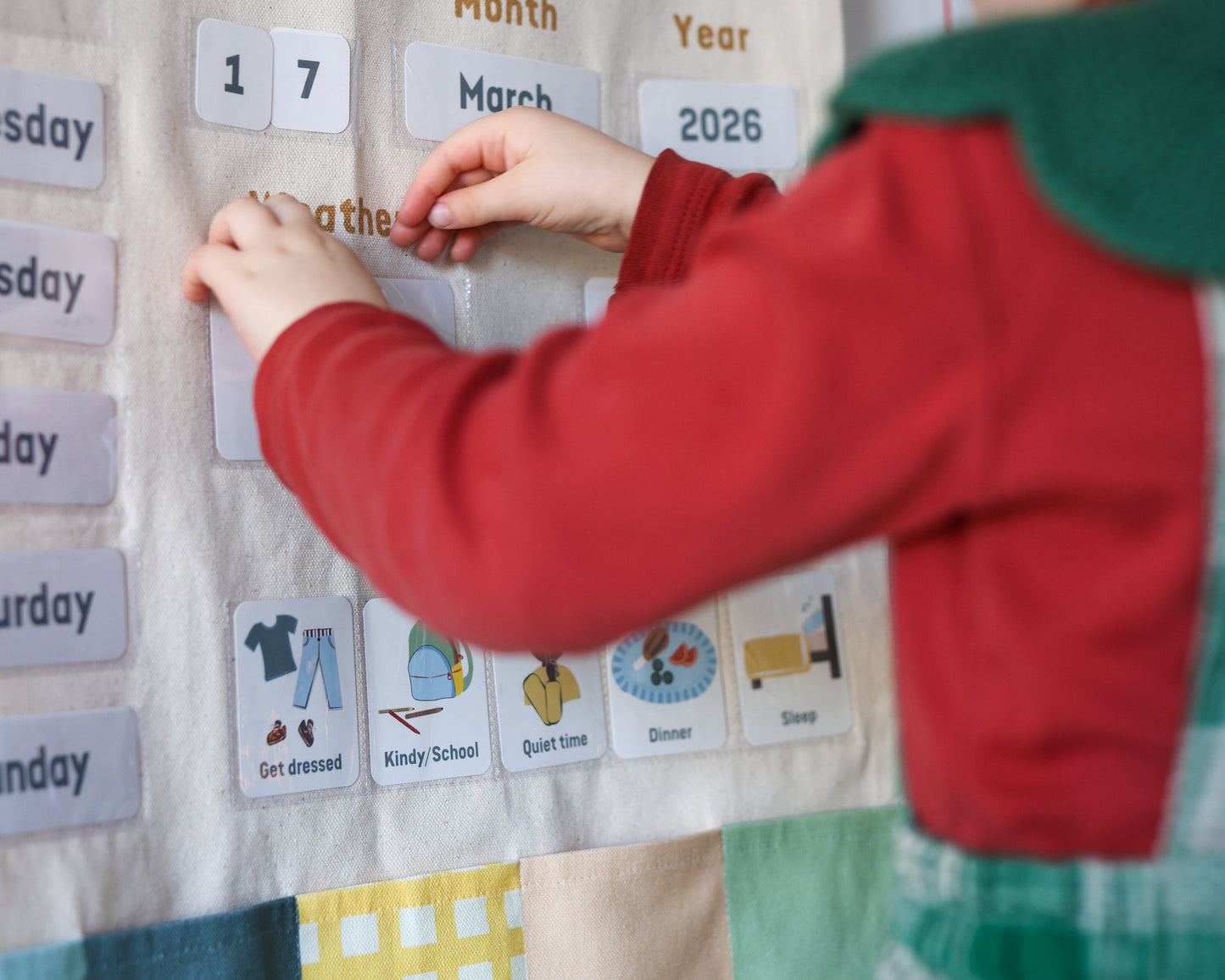 Child interacting with a calendar chart titled 'All About Today' on a white wall.